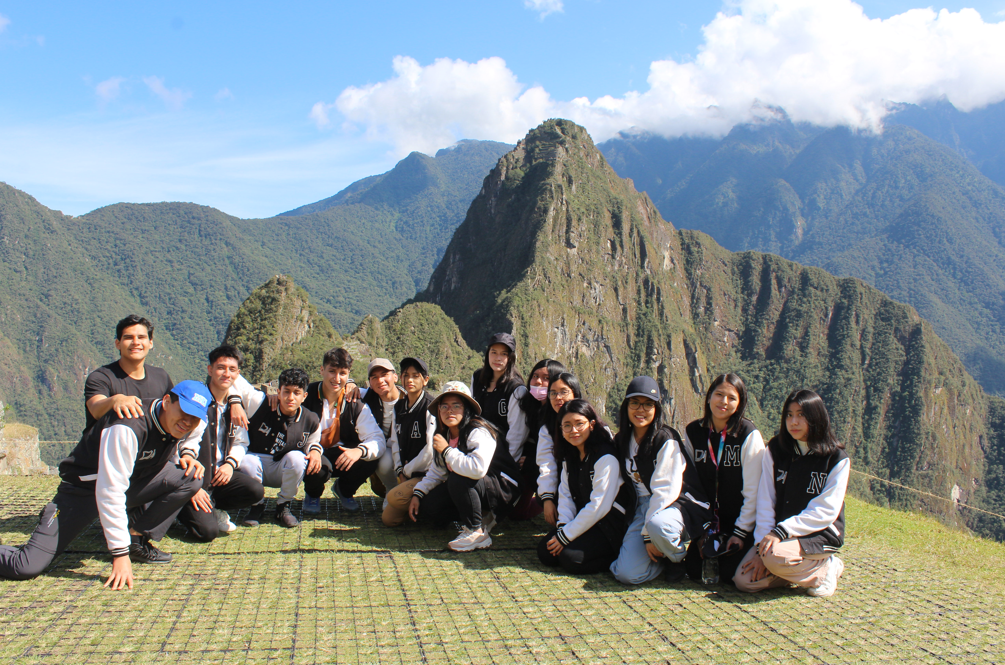 Grupo de estudiantes en la parte alta de Machu Picchu durante viaje de promoción escolar